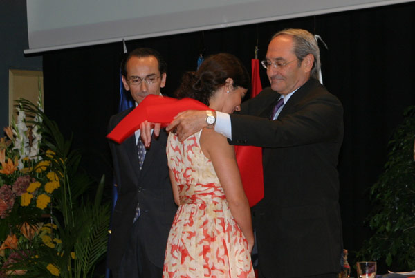 El embajador director de la Escuela Diplomática, Ignacio Sagaz, imponiendo la beca a una estudiante de la XV promoción de licenciados en Derecho de CEU-UCH.