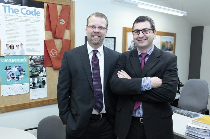 Los investigadores Benjamin Henry Brinkmann, de la Clínica Mayo, y Juan Pardo Albiach, de la CEU-UCH, esta mañana en la Universidad.
