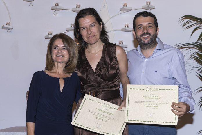 La decana del ICOVV, Inmaculada Ibor, entregando el premio a los profesores de Veterinaria de la CEU UCH Ana Navarro y Héctor Sanz.