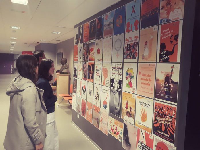 Alumnos del CEU frente a la exposición de carteles que denuncian la violencia de género