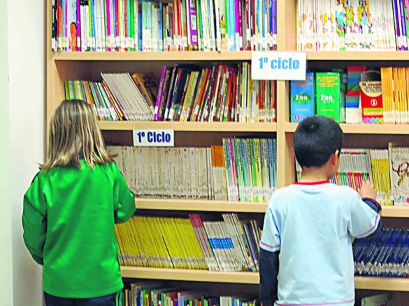 Niños consultan libros en la biblioteca de su centro escolar. / Archivo